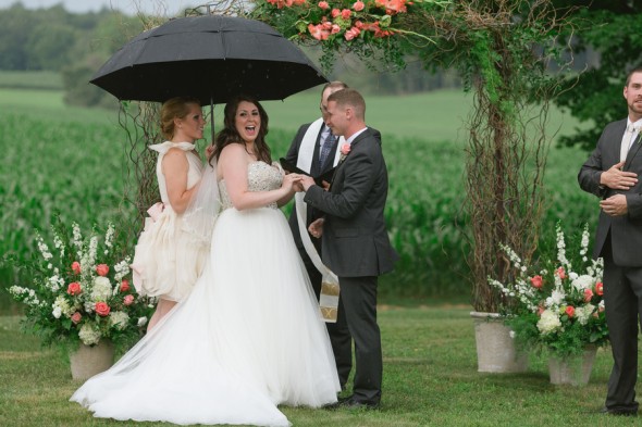 Bridesmaid Holds Umbrella for Bride