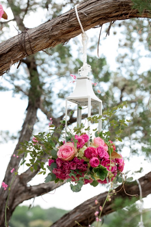 Hanging Lantern Holds Flowers at an Outdoor Wedding